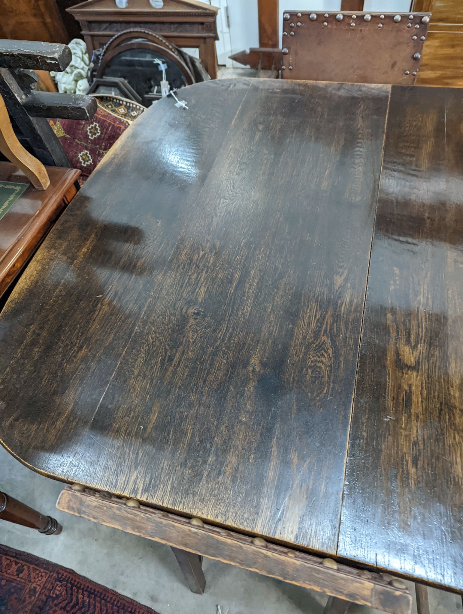 A 1920's oak extending dining table, 238cm extended (two spare leaves), width 120cm, height 74cm together with seven oak dining chairs (one with arms)